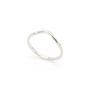 Op de afbeelding: Een eenvoudige zilveren ring met een gebogen, golvend ontwerp.