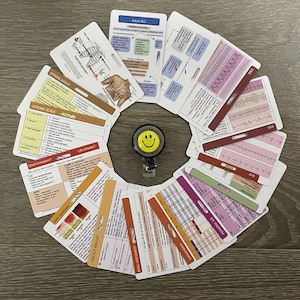 May include: A set of 12 laminated medical reference cards with a variety of topics, including stroke scale, EKG, pediatric visits, and basic assessment. The cards are arranged in a circle around a yellow smiley face keychain.