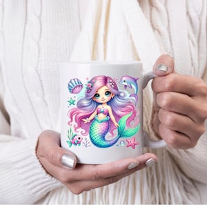 May include: White ceramic mug featuring a colorful illustration of a mermaid with purple and pink hair, a teal tail, and a pink seashell bra. The design includes a dolphin, starfish, and other sea elements.