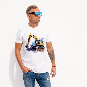 May include: White t-shirt with a watercolour image of a yellow excavator. The excavator has a black bucket and is set against blue and brown paint splatters. The shirt is worn by a person wearing blue sunglasses.