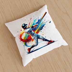 May include: A white pillow with a colorful abstract design featuring a baseball player swinging a bat. The design includes splashes of red, orange, yellow, green, and blue paint.