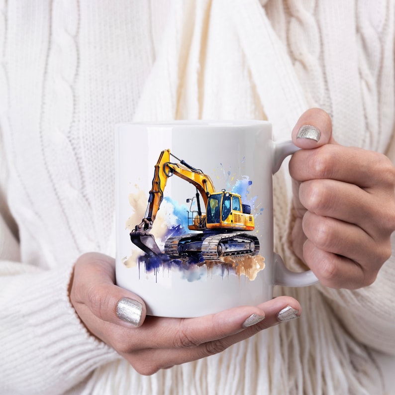 May include: White ceramic mug with a watercolour illustration of a yellow excavator. The design includes blue, brown, and yellow paint splashes. The excavator has a detailed bucket and tracks. The mug is held by a person wearing a white sweater.