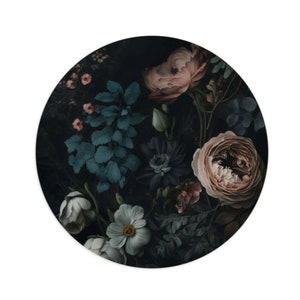 May include: A dark floral print with pink, white, and blue flowers on a black background. The flowers are arranged in a circular pattern.