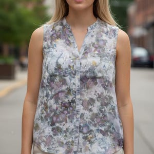 May include: A white ceramic mug with a colorful floral design. The mug features a handle and a wide rim. The flowers are in shades of pink, purple, and yellow. The mug is likely for beverages.