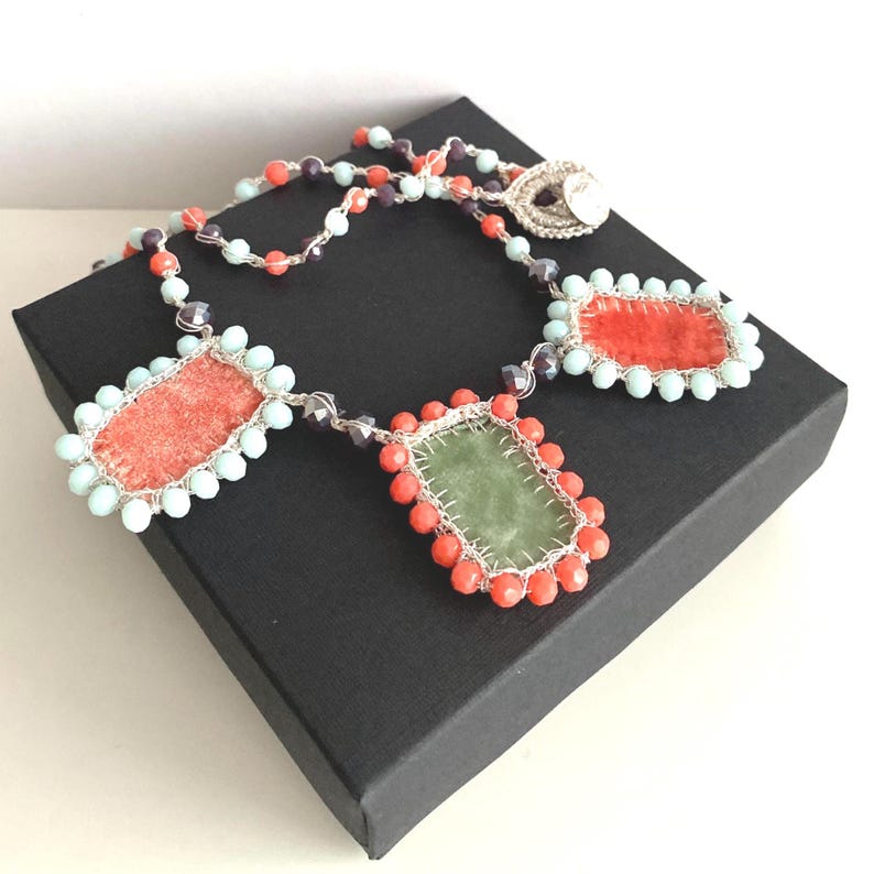Summer necklace embellished with three handmade charms made of orange and green velvet.