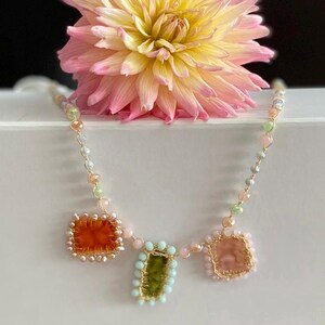 Pastel necklace crocheted with gold jewel yarn and bright colors glass beads. Necklace is embellished with handmade pastel velvet charms. 3 charms made of orange, green and cream velvet.