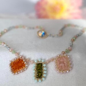 The edge of orange square charm is beaded with mini freshwater pearls. The edge green rectangle charm is beaded with bluish glass beads. The edge of cream charm is beaded with pastel rose glass beads.