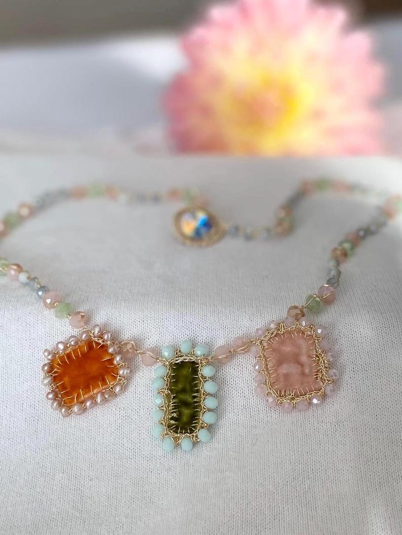 The edge of orange square charm is beaded with mini freshwater pearls. The edge green rectangle charm is beaded with bluish glass beads. The edge of cream charm is beaded with pastel rose glass beads.