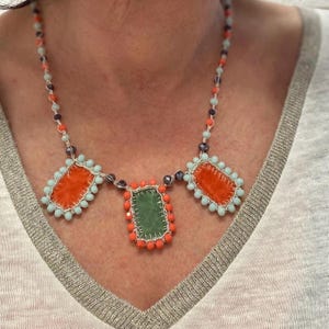 Summer necklace embellished with three handmade charms made of orange and green velvet.
