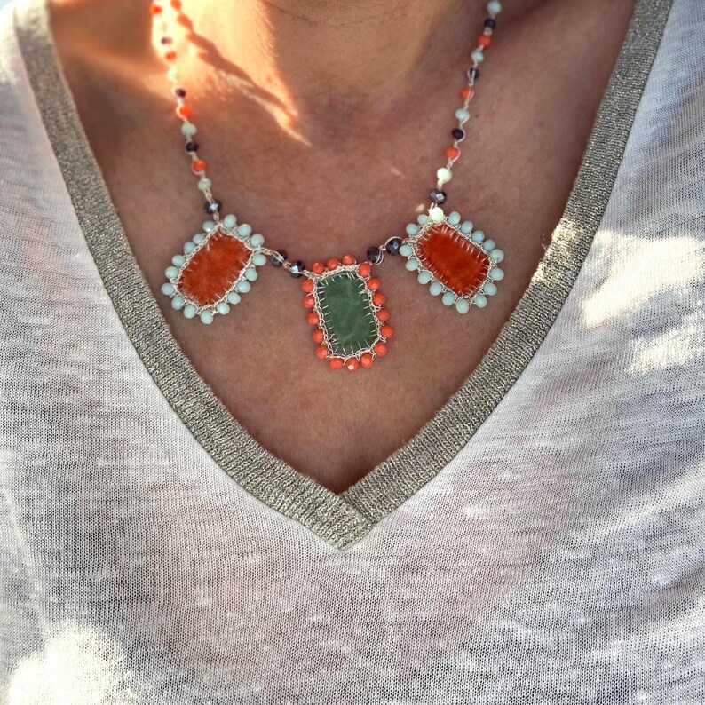 Handmade charm necklace is hand crocheted with silver metallic thread and glass beads.