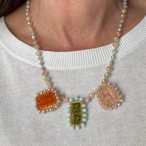 Necklace is embellished with handmade pastel velvet charms. 3 charms made of orange, green and cream velvet. The edge of orange charm is beaded with small freshwater pearls, othe 2 charms beaded with glass beads.