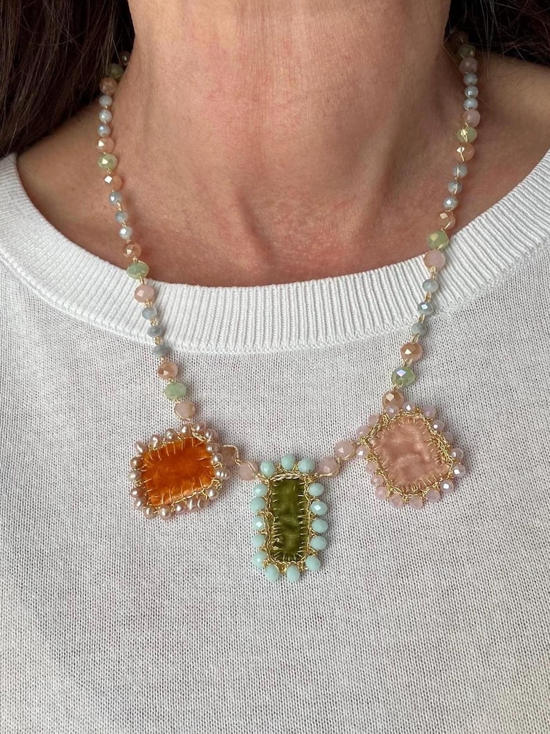 Necklace is embellished with handmade pastel velvet charms. 3 charms made of orange, green and cream velvet. The edge of orange charm is beaded with small freshwater pearls, othe 2 charms beaded with glass beads.