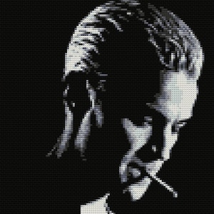 May include: Black and white pixelated portrait of a person with short hair, looking down and to the side. The person's face is partially obscured by their hair.