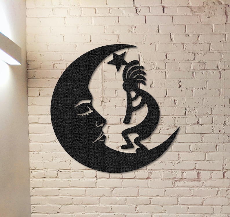 Peut inclure: D&eacute;coration murale en m&eacute;tal noir repr&eacute;sentant un personnage stylis&eacute; de Kokopelli am&eacute;rindien tenant une &eacute;toile, debout sur une lune croissante avec un visage endormi.