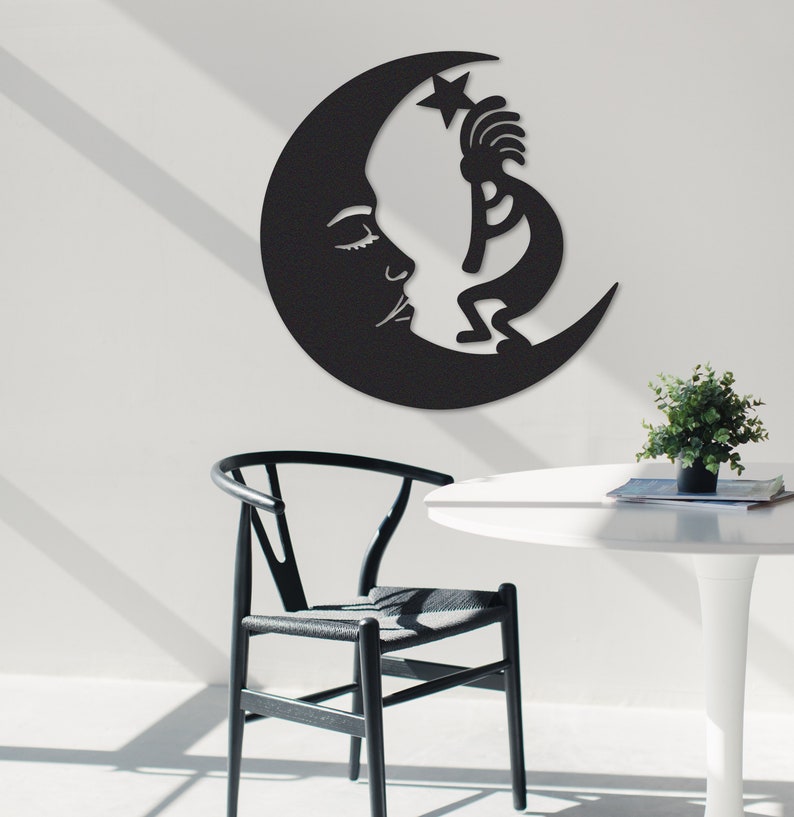 Peut inclure: D&eacute;coration murale en m&eacute;tal noir repr&eacute;sentant une lune croissante avec un visage stylis&eacute; et une figure de Kokopelli atteignant une &eacute;toile.