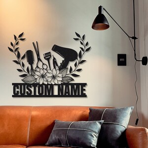 May include: Black metal wall art featuring a hair dryer, scissors, combs, and flowers with the text "CUSTOM NAME".