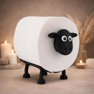 Op de afbeelding: Een grappige toiletpapierhouder in de vorm van een schaap. De witte toiletrol vormt het lichaam van het schaap, met een zwarte kop en poten. De houder is ontworpen om op een oppervlak te staan, wat een leuk element toevoegt aan de badkamerinrichting.