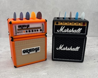 May include: Two miniature guitar amplifier models, one orange with "ORANGE" text and the other black with "Marshall" text. Both have slots holding guitar picks in various colors.