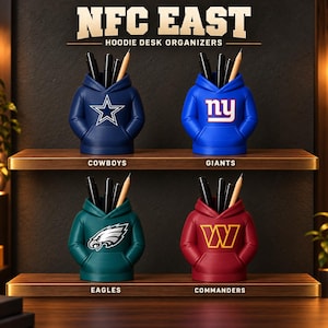 May include: Four desk organizers shaped like miniature hoodies, each featuring a different NFL team logo: the Dallas Cowboys star, New York Giants 'ny', Philadelphia Eagles eagle, and Washington Commanders 'W'. Each holds pens and pencils.