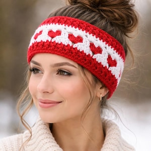 May include: A red and white crochet headband featuring a heart pattern. The headband is made of a soft, textured yarn and is worn around the forehead. The accessory is a winter fashion item.