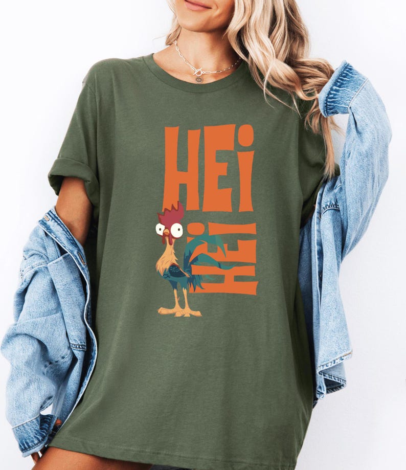 Op de afbeelding: Een groen T-shirt met een oranje afbeelding van een haan en het woord "Hei" dat verticaal wordt herhaald.