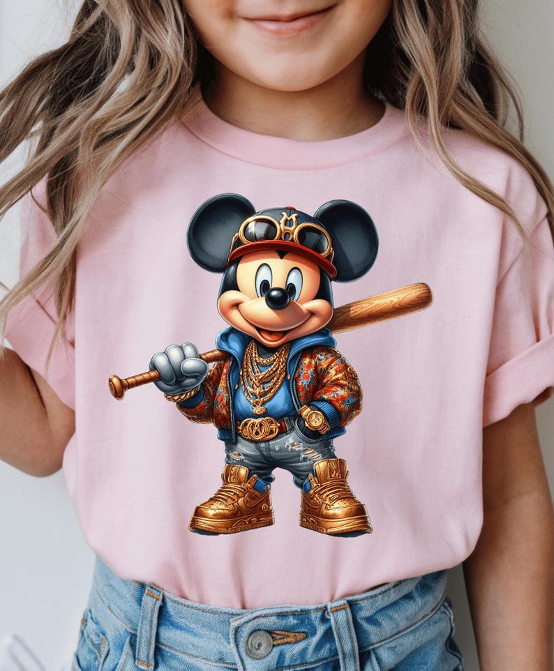 May include: A pink t-shirt with a cartoon image of Mickey Mouse wearing a gold chain, a baseball cap, and sunglasses. Mickey Mouse is holding a baseball bat and is wearing a blue jacket with a floral pattern.