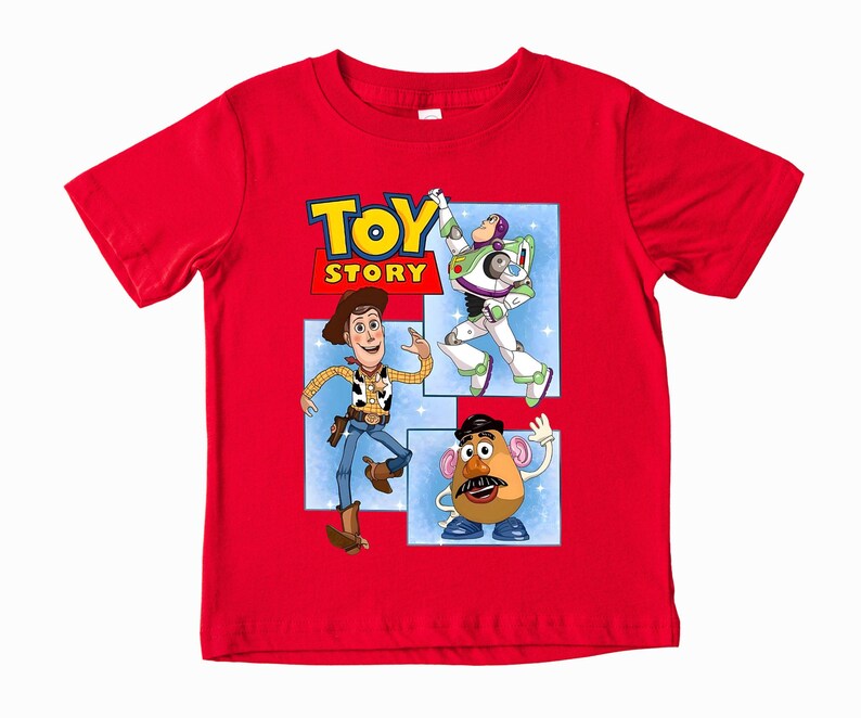 May include: A bright red short-sleeved t-shirt featuring a graphic print of the Toy Story logo and characters Woody, Buzz Lightyear, and Mr. Potato Head. The design is set against a light blue background with white star accents on the shirt front.