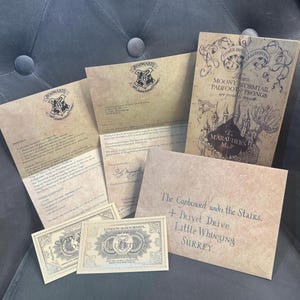 May include: A set of Harry Potter themed stationery, including a letter, envelope, map, and ticket. The letter is addressed to "The Cupboard under the Stairs, 4 Privet Drive, Little Whinging, Surrey."