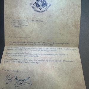 K&ouml;nnte beinhalten: Ein Hogwarts-Zulassungsschreiben, adressiert an The Cupboard Under the Stairs, 4 Privet Drive, Little Whinging, Surrey. Der Brief ist auf Pergamentpapier geschrieben und tr&auml;gt oben das Hogwarts-Wappen. Der Brief informiert den Empf&auml;nger dar&uuml;ber, dass er an der Hogwarts-Schule f&uuml;r Hexerei und Zauberei angenommen wurde. Der Brief ist von Professor McGonagall unterzeichnet.