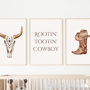 May include: Three framed watercolor prints with a Western theme. The prints feature a bull skull, the text "ROOTIN' TOOTIN' COWBOY", and a cowboy boot with a hat. The color palette includes shades of brown, beige, and white.