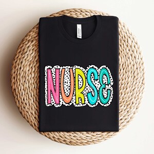 May include: Black t-shirt with the word "NURSE" in colorful letters with white polka dots.