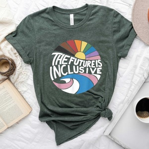May include: A dark green t-shirt with a colorful graphic design of a rainbow circle with a sun and the text "The Future is Inclusive".