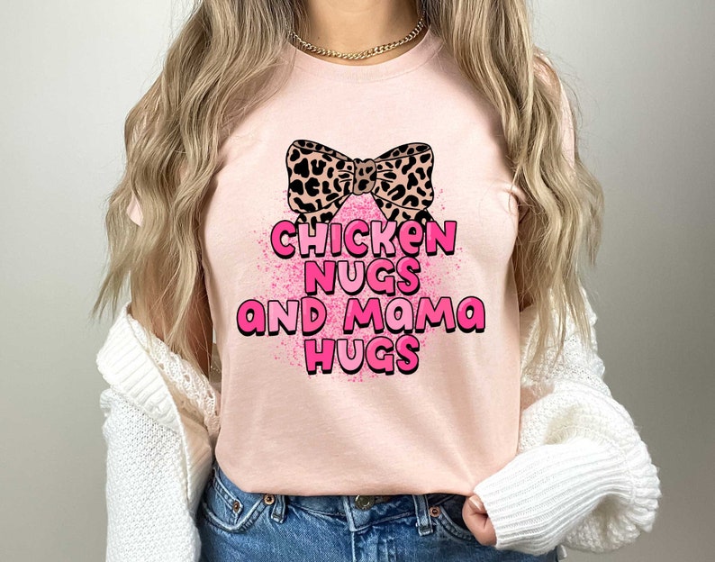 May include: A pink t-shirt with a leopard print bow and the text "Chicken Nugs and Mama Hugs" in pink letters.