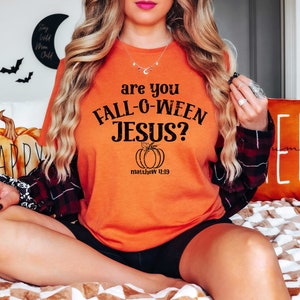 May include: Orange t-shirt with black text that reads "are you FALL-O-WEEN JESUS?" with a small pumpkin graphic and the text "matthew 14:19" underneath.