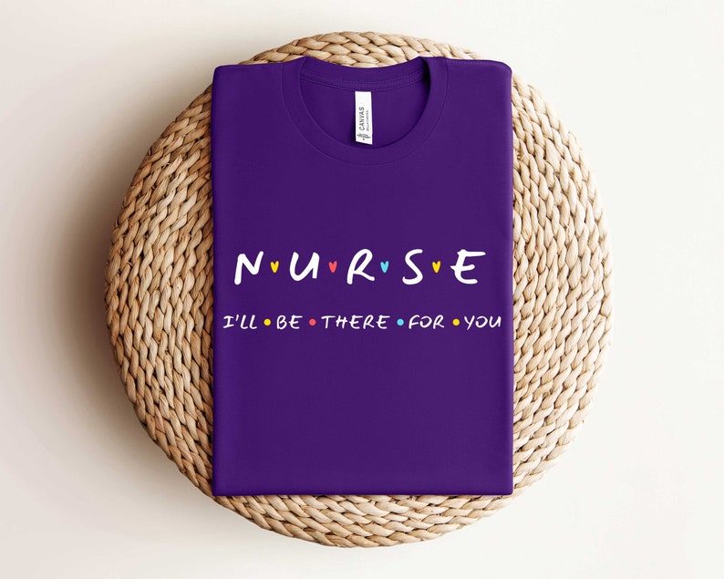 Puede incluir: Camiseta morada con el texto "NURSE" con corazones de colores y el texto "I'll be there for you" en un estilo de fuente similar.