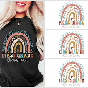 May include: A black t-shirt with a rainbow design and the text "First Grade Dream Team". The rainbow has the words "Teach Them, Love Them, Watch Them Grow" written around it.
