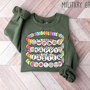 May include: A green sweatshirt with a colorful beaded design that says "Happy Easter".