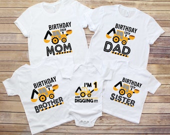 May include: White t-shirts and a onesie with a construction theme. Each shirt has a yellow and black excavator graphic and the words "BIRTHDAY CREW" and a family member's title. The onesie says "I'M 1 AND DIGGING IT!"