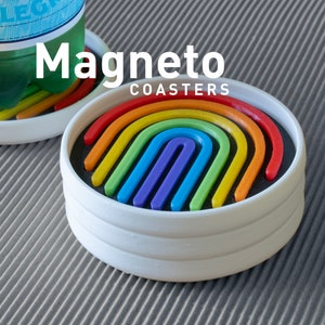 May include: Set of three white coasters with a rainbow design. The coasters are stacked on top of each other. The rainbow design is made up of multiple layers of colored plastic. The coasters are labeled "Magneto Coasters".