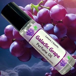 May include: A clear glass perfume oil bottle with a black cap, labeled "Galactic Grape Perfume Oil." The label features a purple grape illustration and the text "Lonora J Scents." The background shows purple grapes.