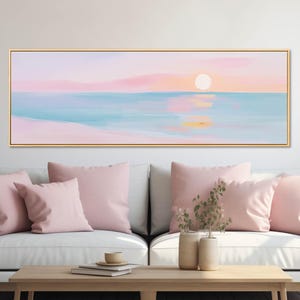 Minimal coastal wall art featuring a pale sun over calm water, presented as a long framed canvas print for beach house or minimalist decor.