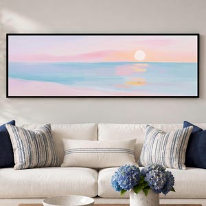 Pastel ocean sunset in soft pink and blue tones, shown as a panoramic black framed canvas print for Scandinavian bedrooms or calming coastal living rooms.