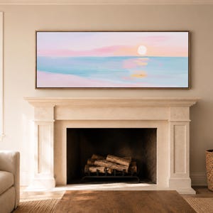 May include: A panoramic rectangular wall art piece featuring an abstract seascape painting with a soft pastel color palette. The artwork displays a pale pink sky, a bright white sun, and calm blue water with gentle reflections in shades of pink and gold.