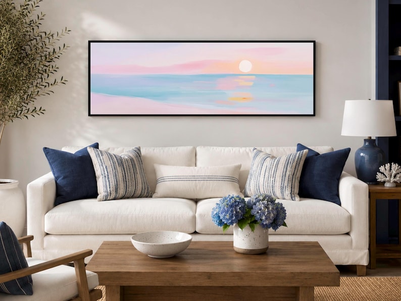 Pastel ocean sunset in soft pink and blue tones, shown as a panoramic black framed canvas print for Scandinavian bedrooms or calming coastal living rooms.