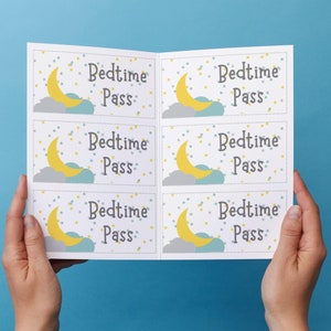 May include: A sheet of "Bedtime Pass" cards held against a blue background. Each card features a yellow crescent moon, gray cloud, and stars. The text "Bedtime Pass" is written in a whimsical font.