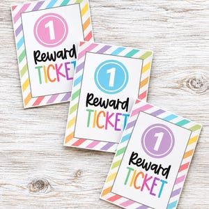 May include: Three rectangular reward tickets with a diagonal striped border in pastel colours. Each ticket features a central circle containing the number 1 and the text Reward TICKET in black and multicoloured lettering on a white background.