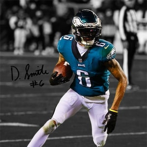 May include: A football player wearing a teal and white jersey with the number 6 and the name "D. Smith" on the front. He is holding a football in his right hand and running towards the camera.