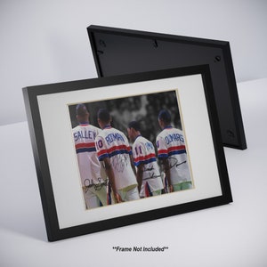 Op de afbeelding: Zwart-witfoto van vier basketballers in uniform. De spelers dragen shirts met de namen "Salley", "Rodman", "Dumars" en "Thomas" op de rug. De foto is ingelijst in een zwart frame.