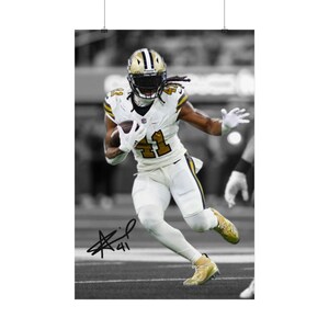 May include: A black and white action photograph of a football player wearing a white jersey with the number 41, white pants, and a helmet, running while holding a football. The image features a prominent black ink autograph and the number 41.