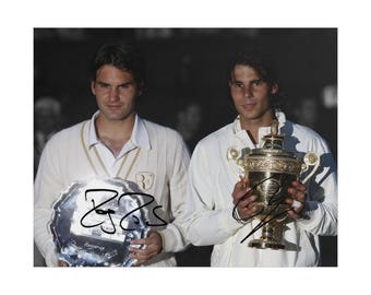 Könnte beinhalten: Ein Foto von zwei Tennisspielern in weißer Kleidung, einer hält einen silbernen Zweitplatzierten-Teller und der andere einen goldenen Pokal. Beide haben schwarze Tintenunterschriften, das RF-Logo ist auf der linken Seite sichtbar.